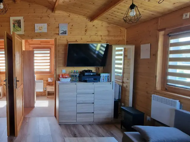 Panorama wnętrza domku — salon, jadalnia i aneks kuchenny w jednej przestrzeni