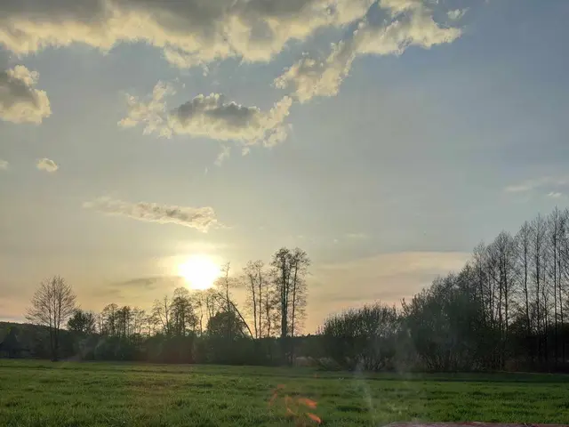 Płonące ognisko na łące przy domku o zachodzie słońca
